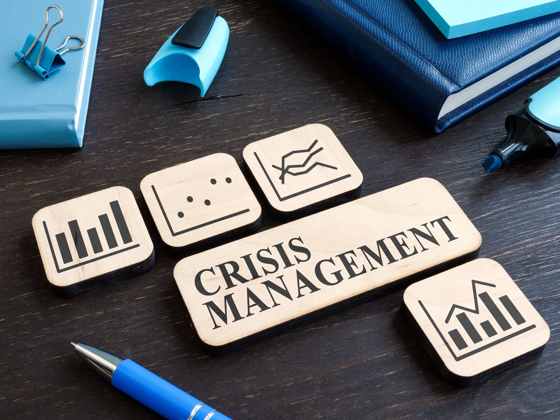 Crisis management on the wooden plate and plates with charts.