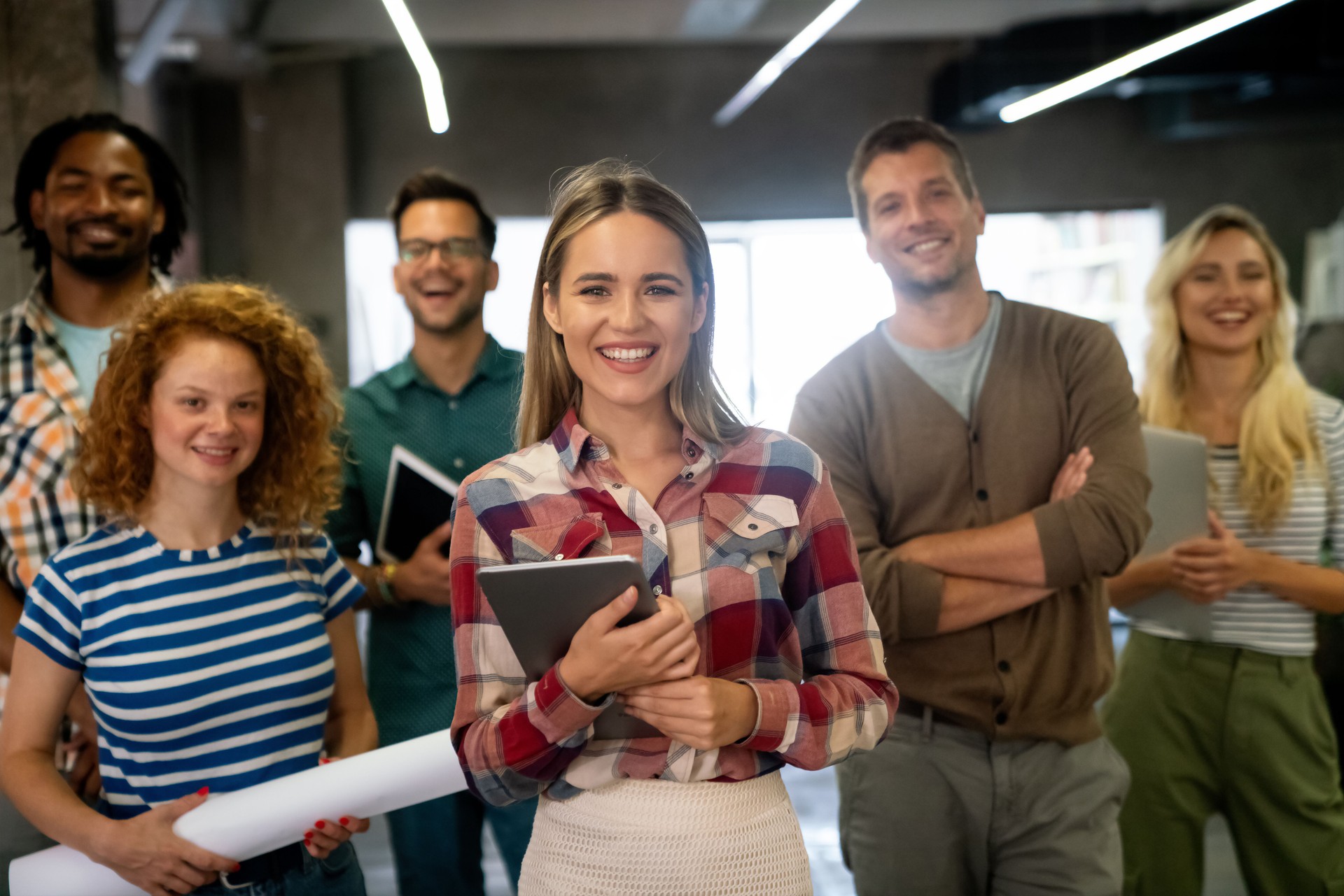Group of young multi-ethnic startup business team collaborating on project in modern office